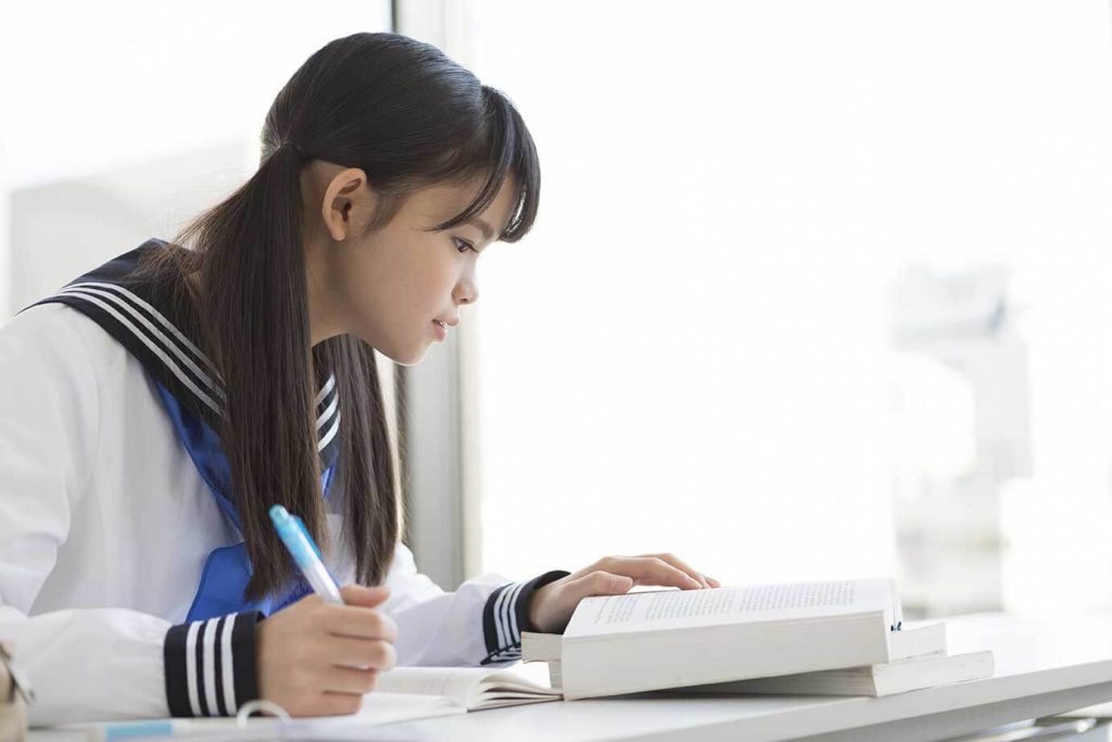 テキストを見て勉強をする女子中学生